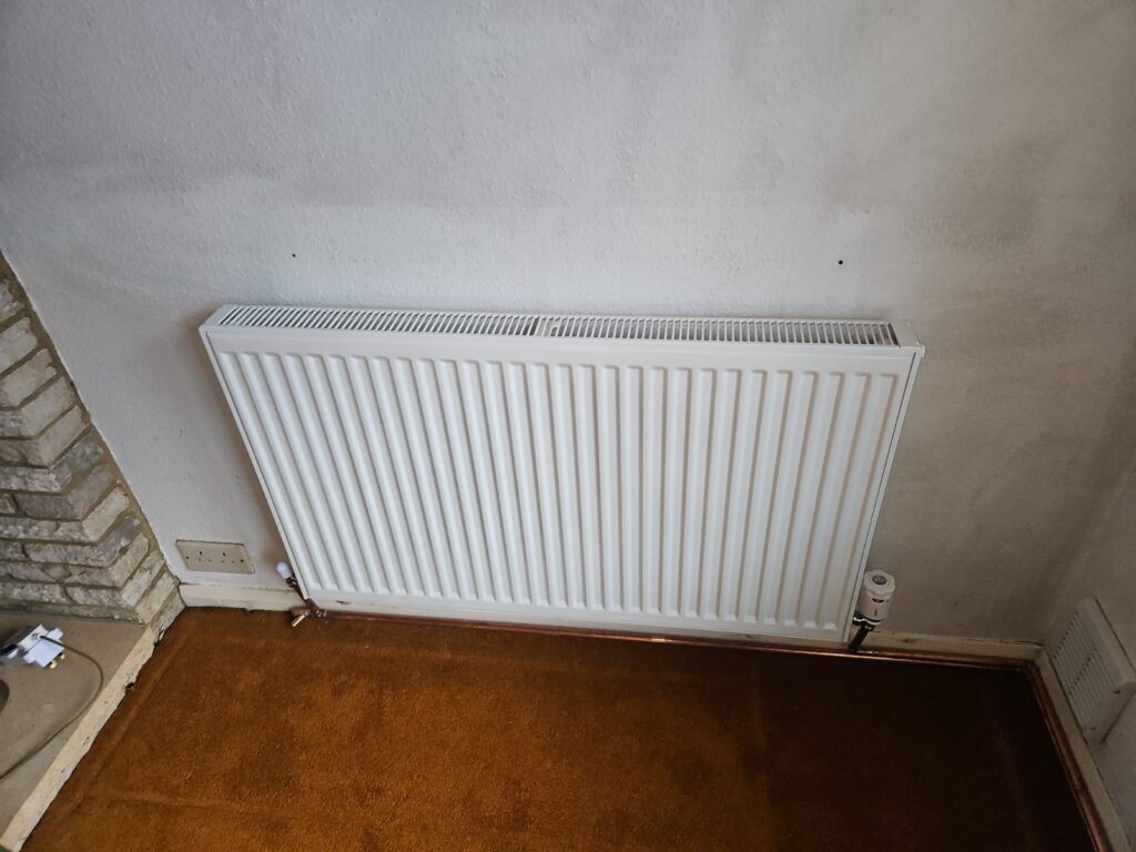 A professional boiler installation in Slough, featuring a Worcester boiler mounted on a red brick wall with a digital display showing a temperature of 74 degrees.